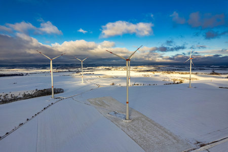 Drone shot of wind turbines in late afternoon light in flat snowy northern German landscapeの写真素材