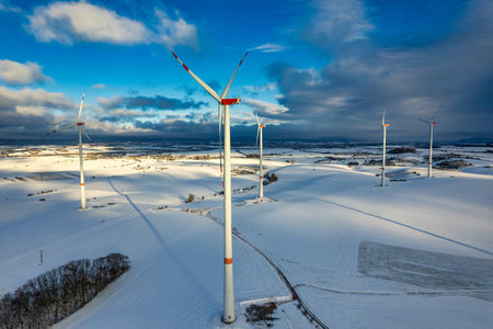 Drone shot of wind turbines in late afternoon light in flat snowy northern German landscapeの写真素材