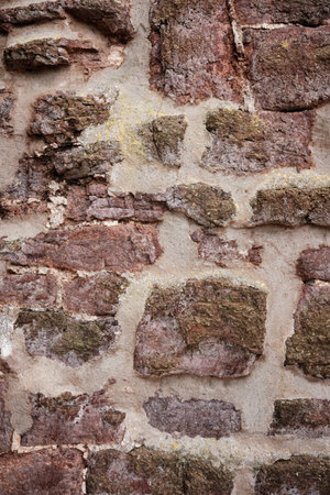 A wall made of stone with a rough texture. The wall is brown and whiteの写真素材