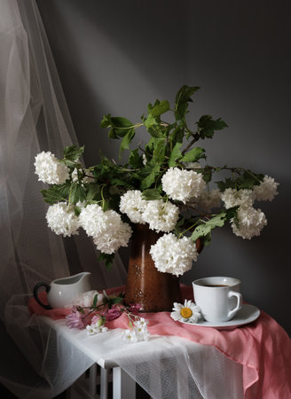 A serene and peaceful composition beautifully showcasing white flowers, an open book, and a warm cup of coffeeの写真素材