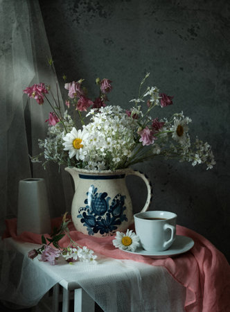 This still life features beautiful white flowers in a vintage pitcher, set against a textured backgroundの写真素材