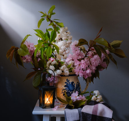 A beautifully serene spring floral arrangement showcasing delicate pink blossoms and an enchanting charming lanternの写真素材