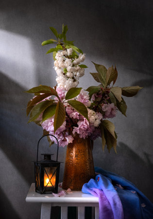 A beautifully serene spring floral arrangement showcasing delicate pink blossoms and an enchanting charming lanternの写真素材
