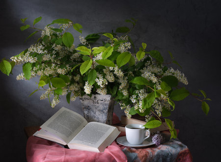The Serene Still Life features a Book, fragrant Tea, and vibrant Flowers in harmonyの写真素材