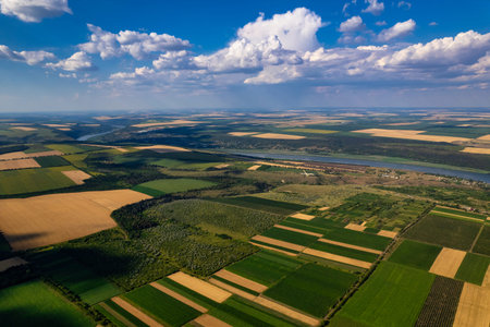 A breathtaking aerial shot captures the vibrant green fields and a meandering river flowing beneath...