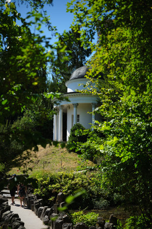 A tranquil and peaceful garden featuring an elegant gazebo, all embraced by lush greeneryの写真素材