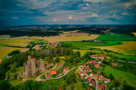 A stunning aerial capture of a historic castle nestled elegantly amidst lush green fields and picturesque scenery. Hanstein castle, Germany.の写真素材