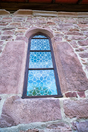 A very narrow window in the stone wall of the old castleの写真素材
