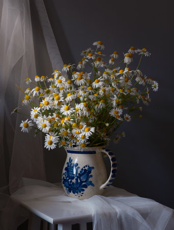 A cheerful collection of daisies in a vintage jug, creating a charming sceneの写真素材