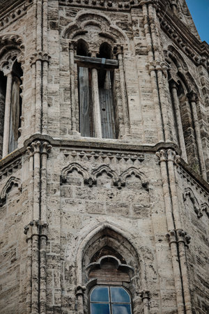 A breathtakingly stunning view showcasing a Gothic church tower set against a bright blue sky above. Facade detail. Germany.の写真素材
