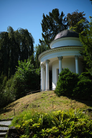 A tranquil and peaceful garden featuring an elegant gazebo, all embraced by lush greeneryの写真素材