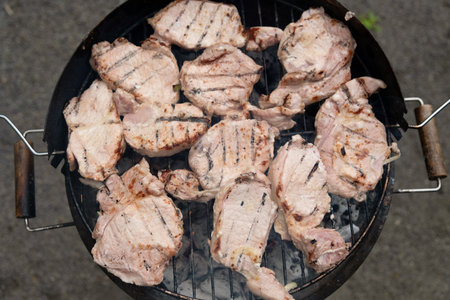 Grilled meat steak on stainless grill depot with flames on dark background. Food and cuisine concept.の写真素材