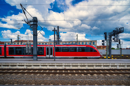 Modern train arriving at platform midday, dynamic commuter scene with clear motion lines, overhead...