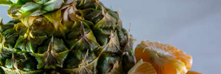 Pineapple and tangerines on a white plate close-up.の写真素材