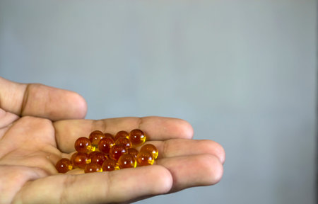 Yellow round tablets on the hand, on a white background.