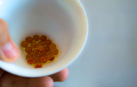 Yellow pellets of the drug in a mug, storage of pellets in a mug.の写真素材