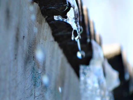 Drops of water dripping from the roof of the house. Drops of water.の写真素材