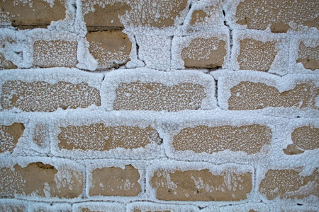 Brick wall in the snow, the wall of the house after the storm .