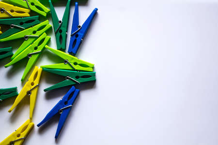 Colorful plastic clothespins on a light background. Space for your inscription. Minimalism, original and creative photography. Be different. The concept of individuality. Vertical wallpaper for a smartphone. High quality photoの写真素材