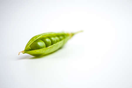 green ripe peas, green beans on a white background, vegetarian food close upの写真素材
