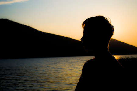 The profile of a young man, the replenishment of vitality in nature, moral fatigue disappears, a person merges with nature.の写真素材