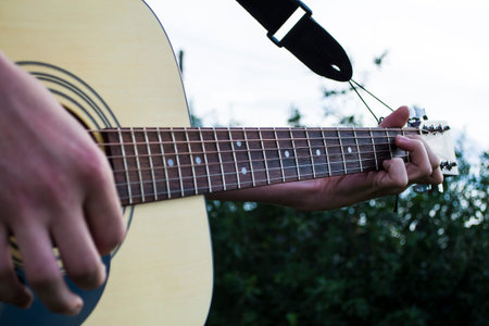 Hand of a man playing country style guitar.