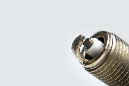 Auto service. New car spark plug as spare part of auto transportation on gray background. High quality photoの写真素材
