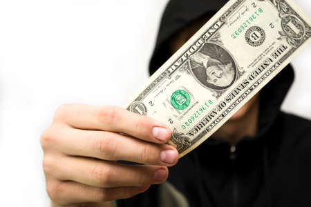 The guy in the hood holds the dollar covering his face on a white background.の写真素材