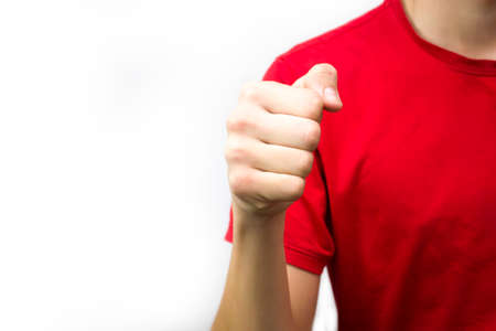 The guy to the red T-shirt clenched his fist on a white background, aggression ready to fight.の写真素材