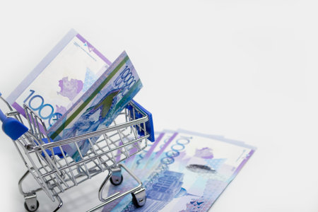 Tenge Kazakhstani money in a trolley on a white background.