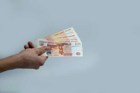 The hand holds 5 thousand rubles. Recalculation of funds.の写真素材
