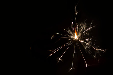 Bengal fire on a dark background, sparks of celebration.