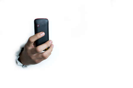 Push-button phone in hand on a white background.の写真素材