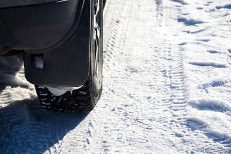The car stands on the snow in studded wheels.の写真素材