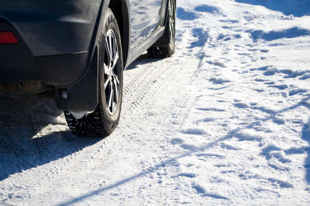 The car stands on the snow in studded wheels.の写真素材