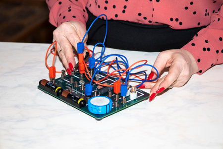 A physics teacher shows children how to assemble an electrical circuit.
