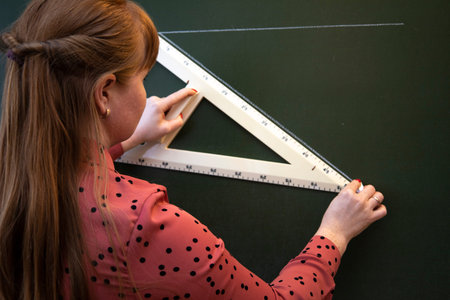 A math teacher explains the lesson to students near the blackboard.の写真素材