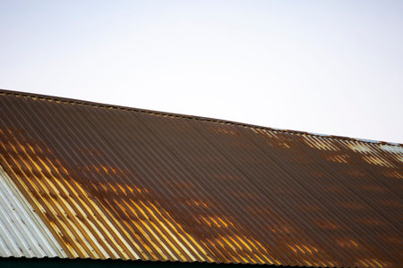 Rusty roof made of corrugated sheet, not a quality material.