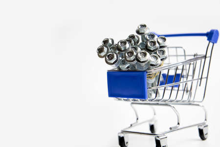 Shopping cart trolley packed with screws illustrating shopping for hardware itemsの写真素材