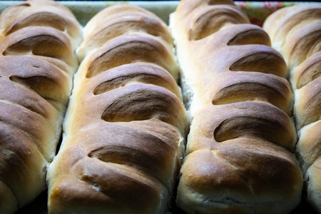Hot loaves are laid out in trays for sale.