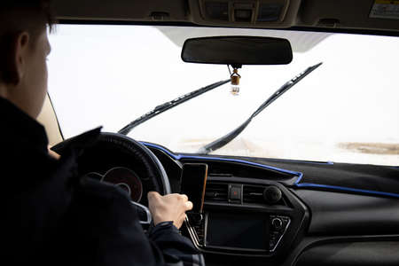 Man looking straight driving a car on the roadの写真素材