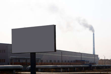 In the foreground is a banner and in the background is a factory and a chimney with smoke.の写真素材