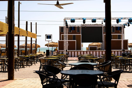 A lovely patio area, complete with several tables and comfortable chairs, features a large screen set up in the background for entertainmentの写真素材