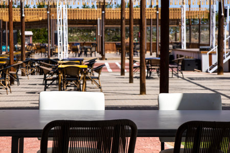 A charming restaurant featuring numerous tables and chairs set up outside, allowing patrons to enjoy...