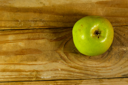Green apple on the old wooden tableの写真素材