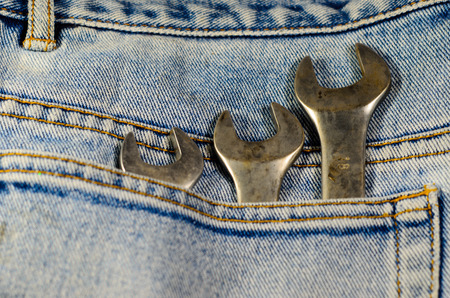 Different wrenches in a pocket of the blue jeansの写真素材