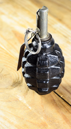 Black hand grenade on the wooden table