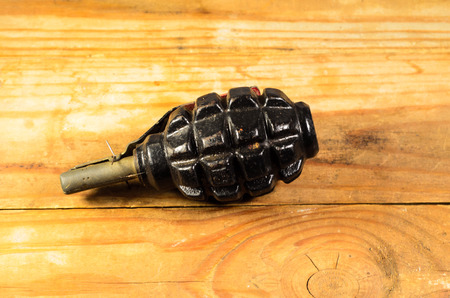Black hand grenade on the wooden tableの写真素材