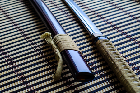 Japanese sword katana on a bamboo matの写真素材