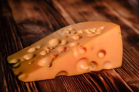 Piece of cheese on rustic wooden tableの写真素材